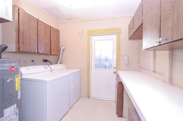 laundry area featuring water heater, washer and clothes dryer, and cabinets