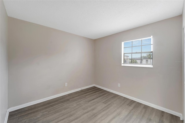 empty room featuring hardwood / wood-style flooring and a textured ceiling