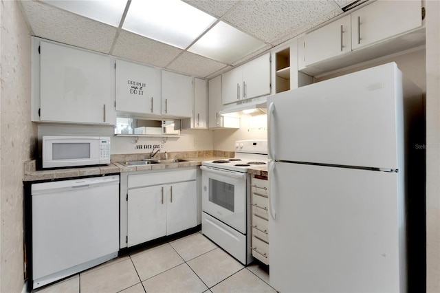 kitchen with a drop ceiling, sink, white cabinets, white appliances, and light tile patterned floors