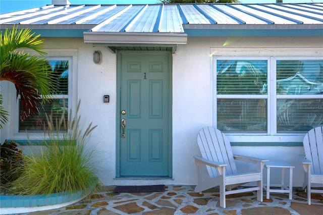 12321 Gulf Blvd, Treasure Island, FL 33706 - doorway to property with stucco siding, a standing seam roof, and metal roof