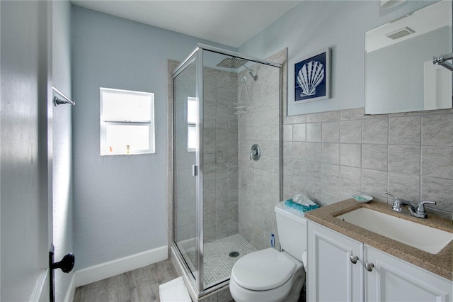 12321 Gulf Blvd, Treasure Island, FL 33706 - bathroom featuring toilet, vanity, a stall shower, and wood finished floors