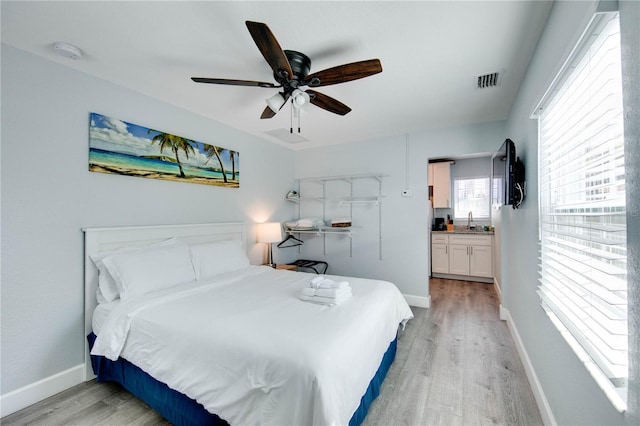 12321 Gulf Blvd, Treasure Island, FL 33706 - bedroom featuring light wood-type flooring, baseboards, a sink, and ceiling fan