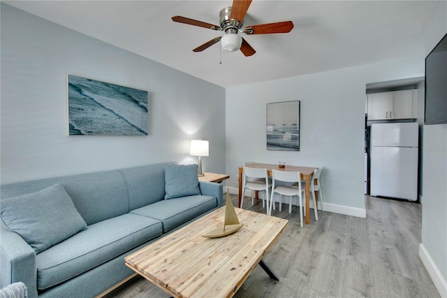 12321 Gulf Blvd, Treasure Island, FL 33706 - living room with light wood-style floors, a ceiling fan, and baseboards