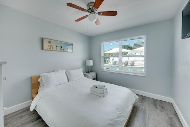 12321 Gulf Blvd, Treasure Island, FL 33706 - bedroom with baseboards, wood finished floors, and ceiling fan