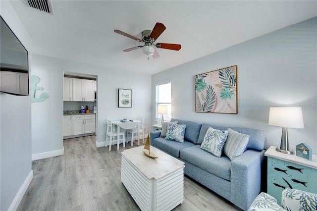 12321 Gulf Blvd, Treasure Island, FL 33706 - living room featuring light wood-style floors, baseboards, and ceiling fan