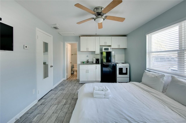 12321 Gulf Blvd, Treasure Island, FL 33706 - bedroom with freestanding refrigerator, light wood-type flooring, and baseboards