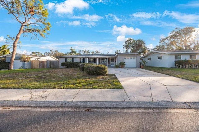 ranch-style home with a garage and a front lawn