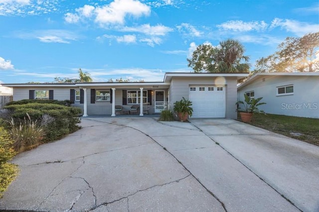 single story home featuring covered porch and a garage