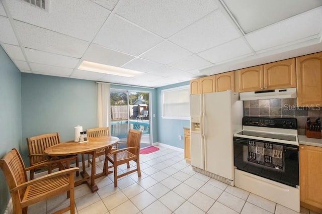 kitchen with a drop ceiling, white appliances, light tile patterned floors, and tasteful backsplash