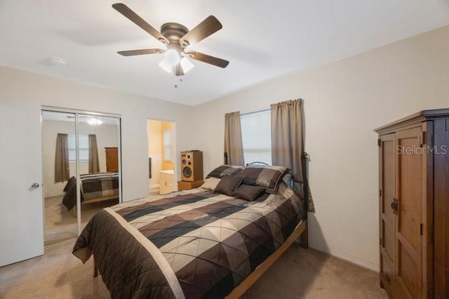 carpeted bedroom featuring ceiling fan, multiple windows, and a closet