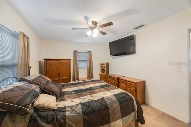 carpeted bedroom featuring ceiling fan and multiple windows