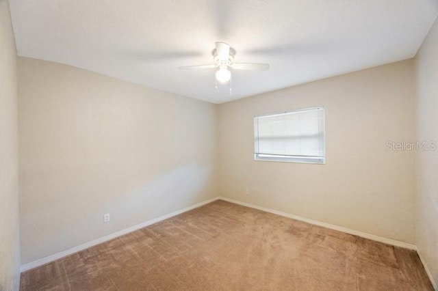 carpeted spare room featuring ceiling fan