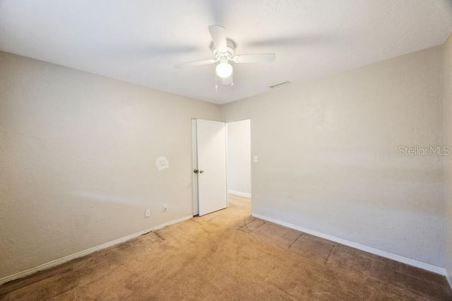 carpeted spare room featuring ceiling fan