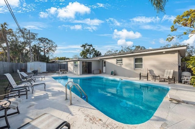 view of pool featuring a patio area and a shed