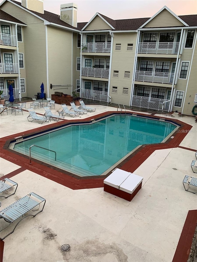 pool at dusk with a patio