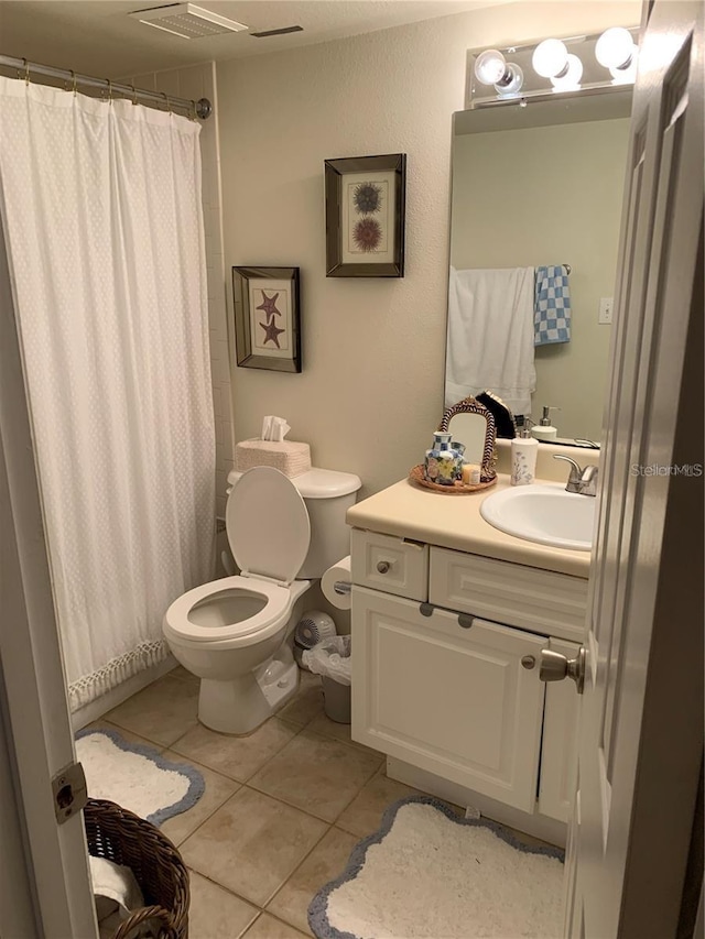 bathroom featuring curtained shower, tile patterned flooring, vanity, and toilet