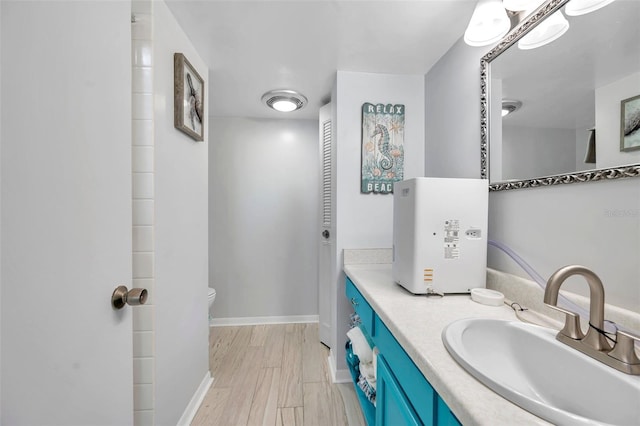 bathroom with vanity, hardwood / wood-style flooring, and toilet