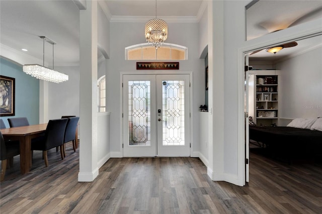 foyer featuring crown molding, french doors, a chandelier, and dark hardwood / wood-style floors