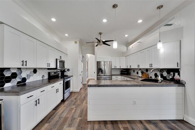 kitchen featuring appliances with stainless steel finishes, decorative light fixtures, white cabinetry, and dark hardwood / wood-style floors