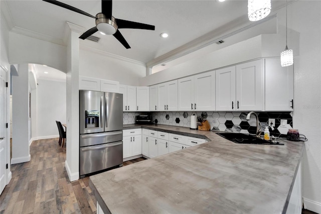 kitchen featuring stainless steel fridge with ice dispenser, sink, white cabinets, and pendant lighting