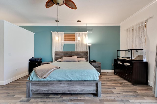 bedroom featuring hardwood / wood-style flooring, ceiling fan, and crown molding