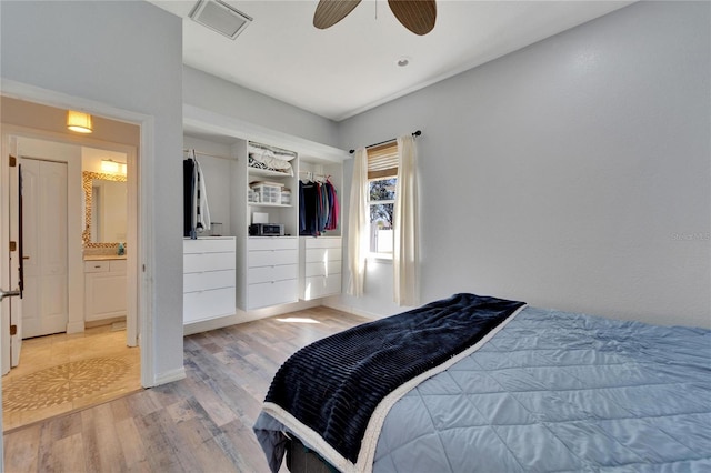 bedroom with light wood-type flooring, ensuite bath, and ceiling fan