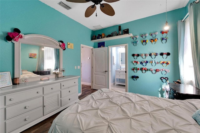 bedroom with dark hardwood / wood-style flooring, ceiling fan, and connected bathroom