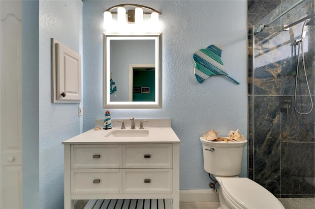 bathroom with vanity, toilet, and a tile shower