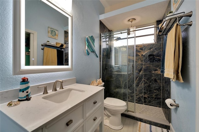 bathroom with hardwood / wood-style floors, vanity, toilet, and walk in shower