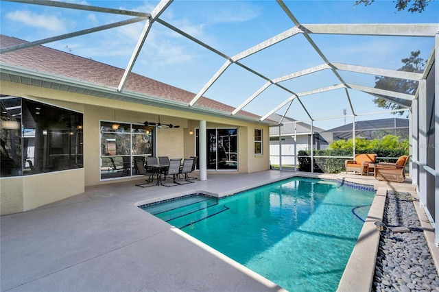 view of swimming pool with a patio, ceiling fan, and a lanai