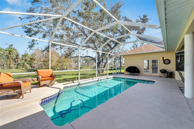 view of swimming pool featuring glass enclosure, a patio area, and french doors