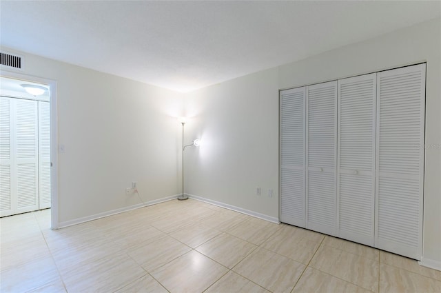 unfurnished bedroom featuring light tile patterned floors and a closet