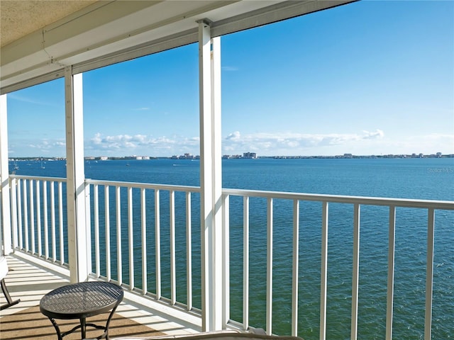 sunroom featuring a water view