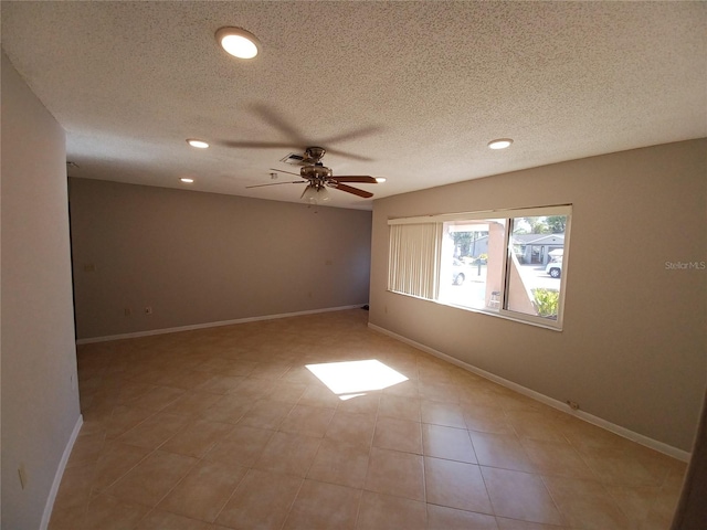 empty room with ceiling fan and a textured ceiling