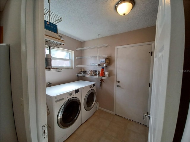 laundry room with washer and dryer and a textured ceiling