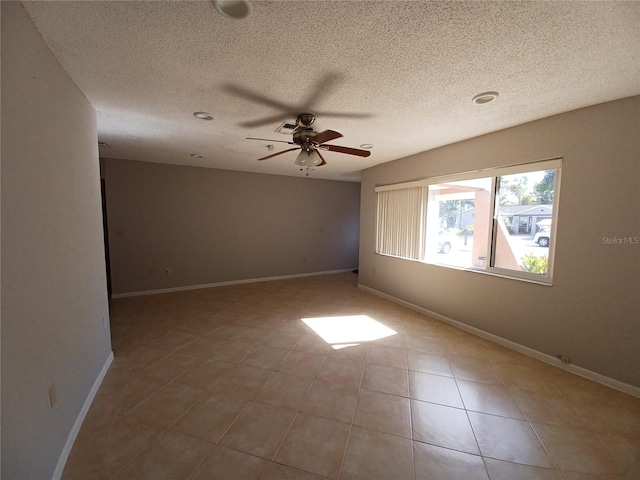 tiled empty room featuring a textured ceiling and ceiling fan