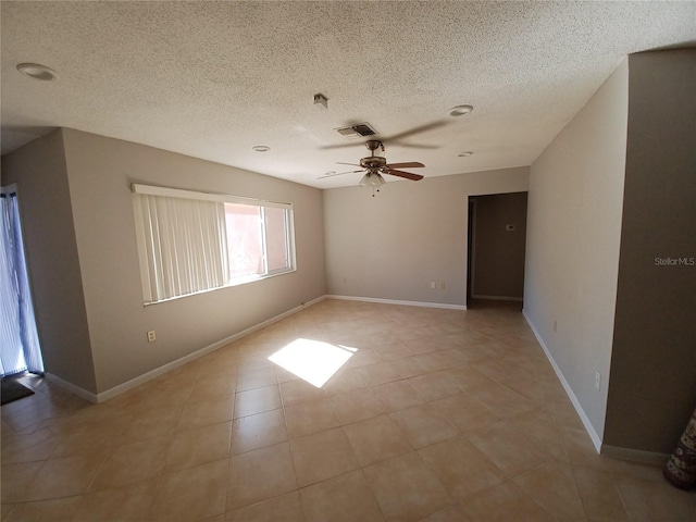 tiled spare room with ceiling fan and a textured ceiling