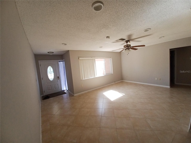 tiled foyer with ceiling fan and a textured ceiling