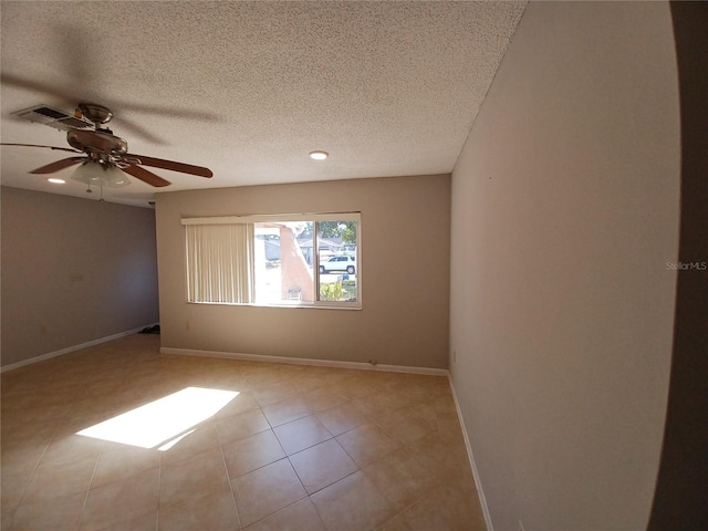 tiled spare room featuring ceiling fan and a textured ceiling