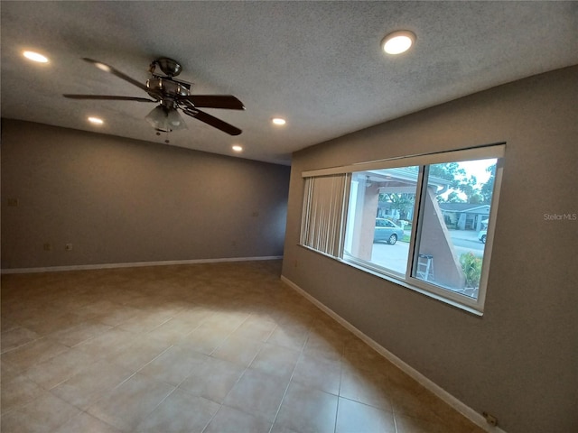 empty room featuring ceiling fan and a textured ceiling