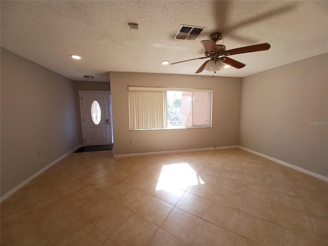 entryway featuring ceiling fan, light tile patterned floors, and a textured ceiling