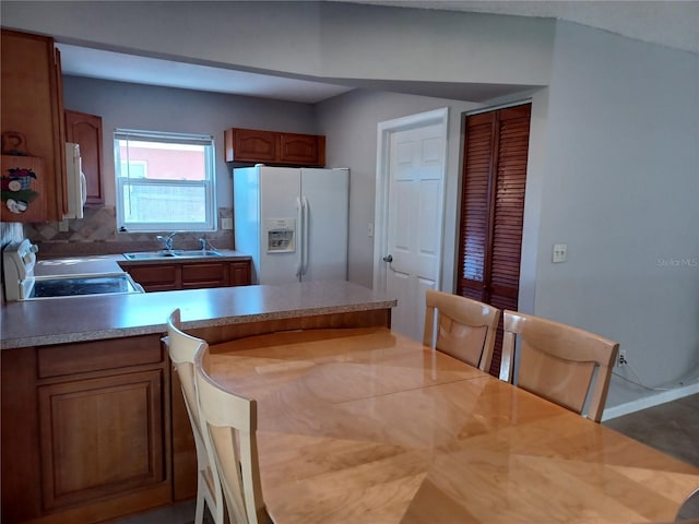 kitchen featuring sink, backsplash, and white appliances