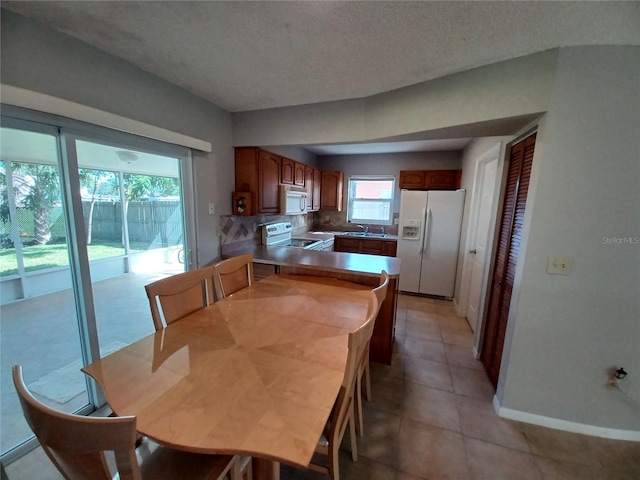 tiled dining room with sink and a textured ceiling