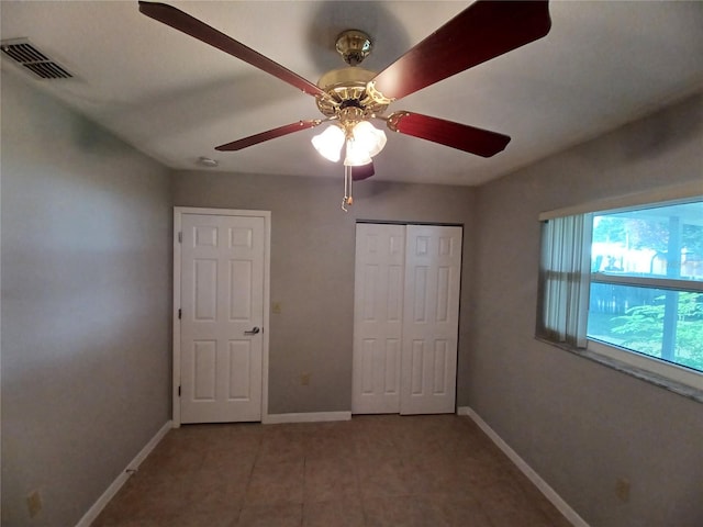 unfurnished bedroom with ceiling fan and a closet