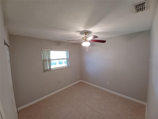 empty room featuring ceiling fan and a textured ceiling