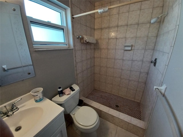 bathroom with vanity, toilet, and tiled shower