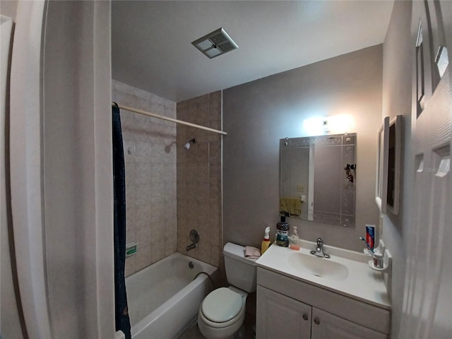 full bathroom featuring vanity, tiled shower / bath combo, and toilet