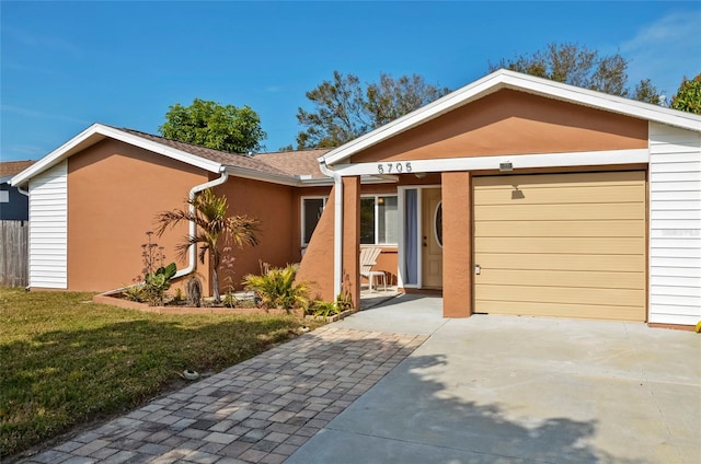 ranch-style home featuring a garage and a front lawn