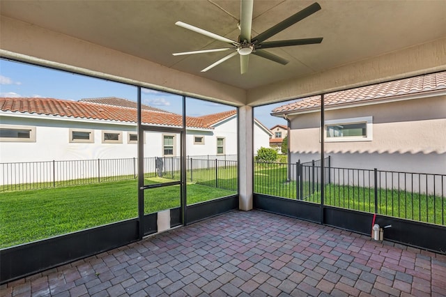 unfurnished sunroom featuring ceiling fan