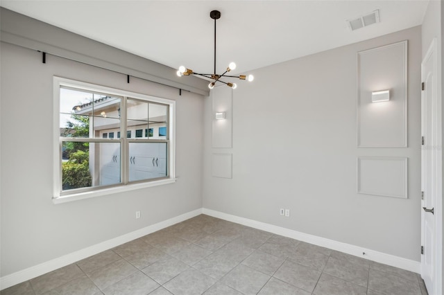 tiled empty room with an inviting chandelier